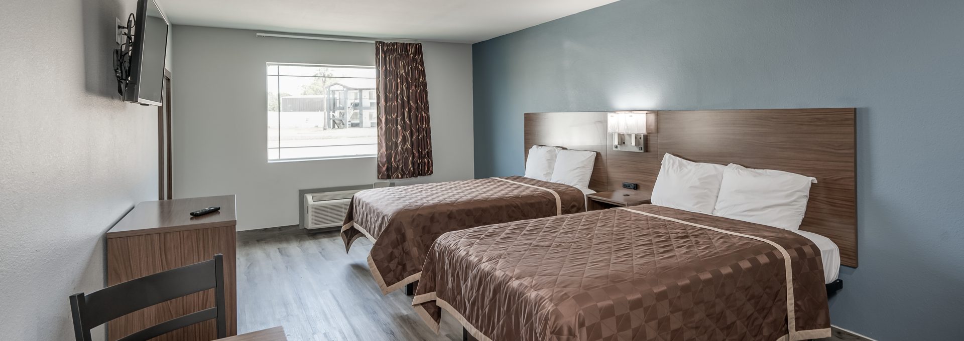 a hotel room with two beds and a television at The  Studios At Channelview